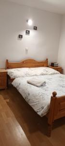sypialnia z dużym łóżkiem z drewnianą ramą w obiekcie Chata na Plantáži w Habówce