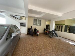 a car parked in a garage with motorcycles parked in it at SSN Home Stays in Bangalore near PLAY Arena in Bangalore