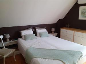 a bedroom with a large white bed and a chair at Huis met 4 slaapkamers tussen Antwerpen en Brussel in Rumst