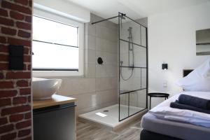een badkamer met een douche, een bed en een wastafel bij Hotel Weilerhof in Dormagen
