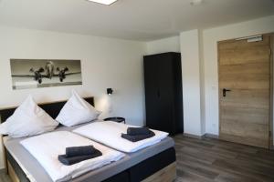 een slaapkamer met een bed met 2 kussens erop bij Hotel Weilerhof in Dormagen