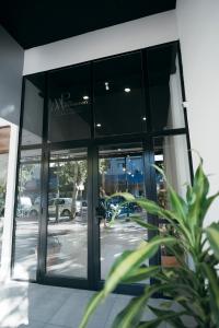 une porte en verre d'un bâtiment avec une personne à l'intérieur dans l'établissement Patio Mediterraneo Apart Hotel, à San Rafael