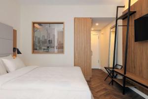 a hotel room with a bed and a television at Radisson Blu Hotel Frankfurt in Frankfurt