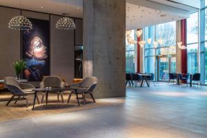 a lobby with a table and chairs and a painting at Radisson Blu Hotel Frankfurt in Frankfurt