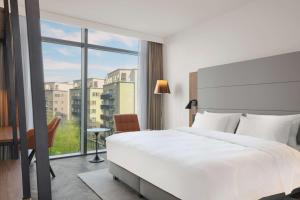 a bedroom with a large white bed and a window at Radisson Blu Hotel Frankfurt in Frankfurt