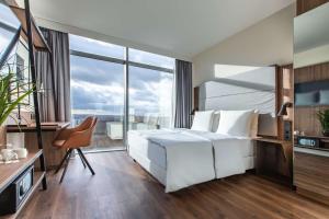a bedroom with a white bed and a large window at Radisson Blu Hotel Frankfurt in Frankfurt