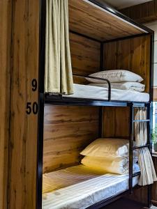 two bunk beds in a room with a wooden wall at Aiva Hostel in Bishkek