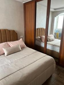 - une chambre avec 2 lits et un grand miroir dans l'établissement Apparemment DarBouazza AquaParc FibreWifiParkingSecurity, à Dar Bouazza