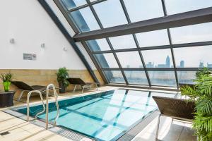 a swimming pool in a building with windows at Radisson Blu Hotel Frankfurt in Frankfurt