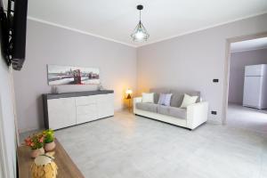 a white living room with a couch and a kitchen at Claretta in Giaveno