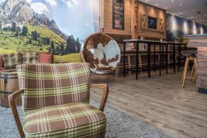 a room with two chairs and a bar with a mountain mural at Cocoon Hauptbahnhof in Munich