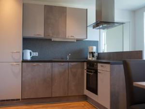 a kitchen with brown cabinets and a sink at Pleasant holiday home near centre in Eben im Pongau