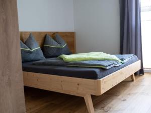 una cama de madera con almohadas azules encima. en Pleasant holiday home near centre, en Eben im Pongau