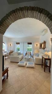 un ampio soggiorno con divani e tavolo di Villa Margherita a Santa Margherita di Pula
