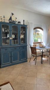 niebieska szafka w salonie ze stołem w obiekcie Villa Margherita w mieście Santa Margherita di Pula