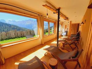 Habitación con sillas y ventana grande con vistas. en Spacious holiday home near ski-lift en Umhausen