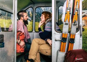 a man and woman sitting inside of a train with skis at Cocoon Hauptbahnhof in Munich