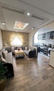 Il comprend un grand salon avec des canapés et une cuisine. dans l'établissement Apparemment DarBouazza AquaParc FibreWifiParkingSecurity, à Dar Bouazza