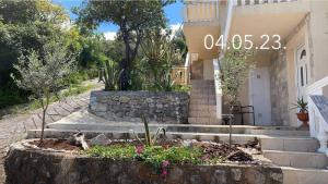 a house with a bunch of plants in front of it at Apartman Copacabana in Krašići