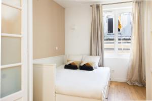 a white bed in a room with a window at Charming Suite 1bdr Saint Honoré Parisian Escape in the Heart of the City NO ELEVATOR in Paris