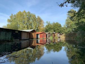 une rangée de maisons près d'une rivière arborée dans l'établissement Lovely holiday home near centre, à Wustrow