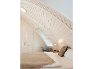Lovely holiday home near centre في Wustrow: سرير في غرفة ذات سقف أبيض