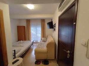 Zimmer mit einem Bett, einem Sofa und einem Fenster in der Unterkunft Apartman 1 in Vrnjačka Banja