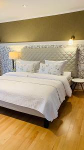 una camera da letto con un grande letto con lenzuola e cuscini bianchi di Gästezimmer - Mespelbrunn a Mespelbrunn