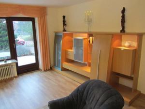 um quarto com uma sala de estar com uma televisão e uma porta em Nice holiday home near town centre em Gneversdorf