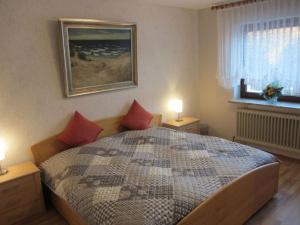 um quarto com uma cama com almofadas vermelhas em Nice holiday home near town centre em Gneversdorf
