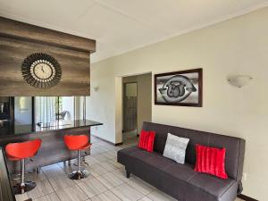 a living room with a couch and red chairs at Emlanjeni Guest Lodge in White River