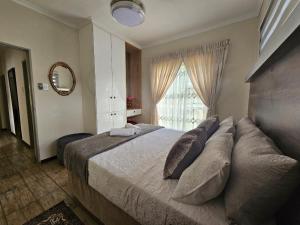 a bedroom with a large bed and a window at Emlanjeni Guest Lodge in White River +59 photos