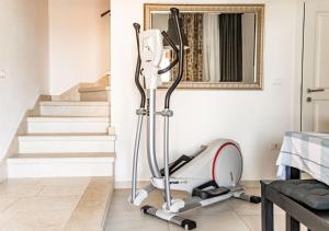 een kamer met een fitnessapparaat naast de trap bij Beautiful Villa Torre I with whirlpool in Tar in Frata