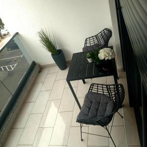 einen Balkon mit 2 Stühlen und einem Tisch mit Blumen in der Unterkunft Premium Center in Trebinje