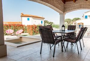 een tafel en stoelen op een terras bij Beautiful Villa Torre I with whirlpool in Tar in Frata