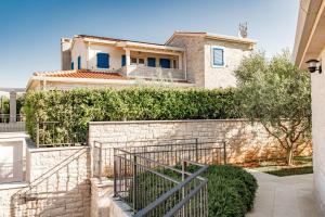 een huis met een stenen muur en een hek bij Beautiful Villa Torre I with whirlpool in Tar in Frata