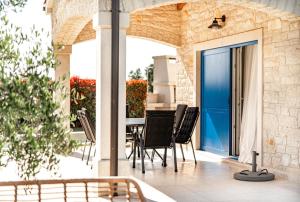 een terras met zwarte stoelen en een blauwe deur bij Beautiful Villa Torre II with whirlpool in Tar in Frata