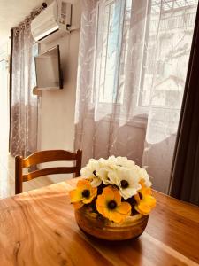 een vaas met bloemen op een houten tafel bij Parthenis Apartment 2 in Pythagoreio