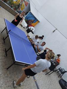 um grupo de pessoas em pé em torno de uma mesa azul em Onefam Madrid em Madri