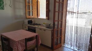 une cuisine avec une table et une cuisinière ainsi qu'une fenêtre dans l'établissement La Padula, à Lido Conchiglia