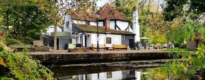 a house sitting on the side of a river at Little Acorns in St. Albans