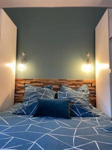 uma cama com lençóis e almofadas azuis num quarto em T2 avec grand jardin,plage à pieds quartier des Lônes em Six-Fours-les-Plages