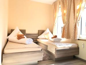 a bedroom with two beds with towels on them at Pension Goldenes Vogtland in Adorf