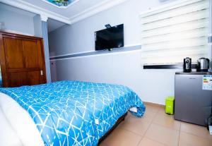 1 dormitorio con 1 cama y TV de pantalla plana en NK HOME en Nsimalen