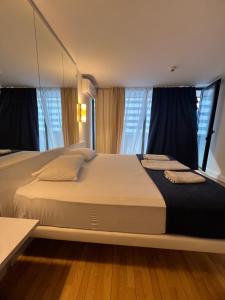 a large bed in a room with windows at Orbi city Aparthotel in Batumi