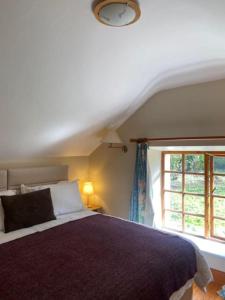 Un dormitorio con una cama grande y una ventana en The Gatelodge, Hilton Park, en Monaghan