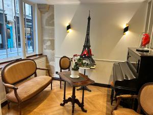 a living room with a table and the eiffel tower at Hotel du Dragon in Paris