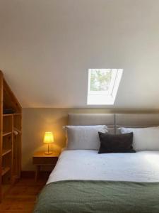 a bedroom with a bed with a lamp and a window at The Gatelodge, Hilton Park in Monaghan