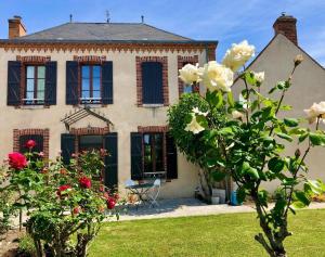ein altes Haus mit Rosen davor in der Unterkunft Maison cosy, cheminée jardin proche centre ville in La Gollotte