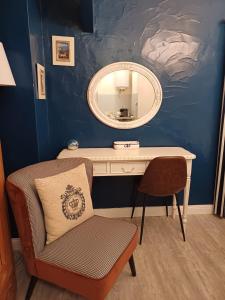 a dressing table with a mirror and a chair at Le chant des oiseaux in Cambo-les-Bains